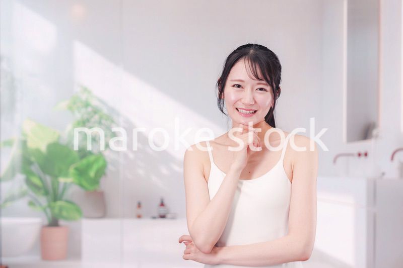 笑顔でビューティーケアをする若い女性