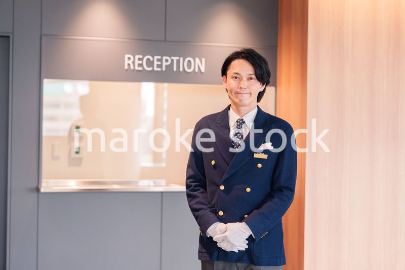 笑顔で接客をするホテルマンの男性