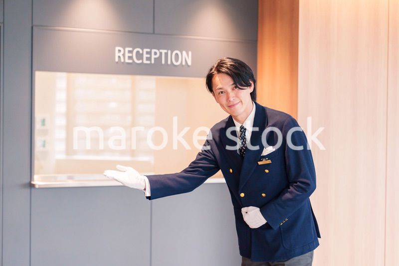 笑顔で接客をするホテルマンの男性