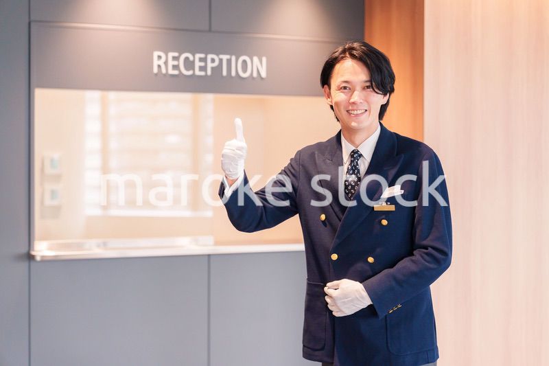 笑顔で接客をするホテルマンの男性