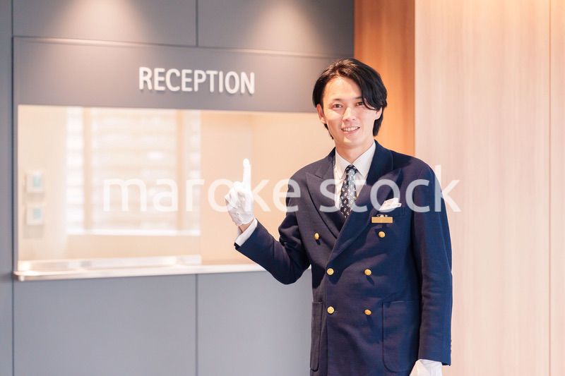 笑顔で接客をするホテルマンの男性