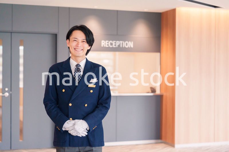 笑顔で接客をするホテルマンの男性
