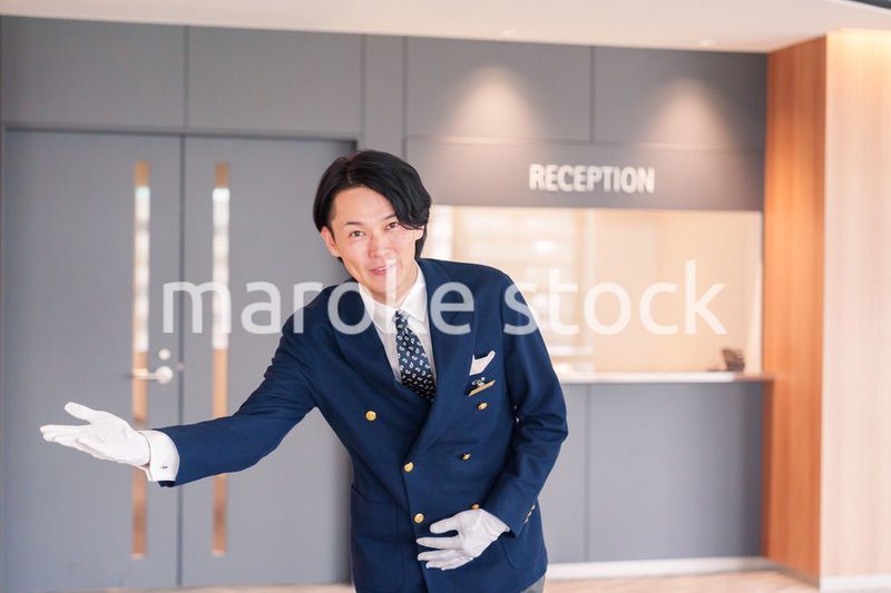 笑顔で接客をするホテルマンの男性
