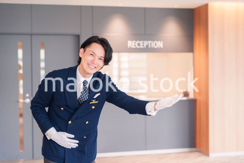 笑顔で接客をするホテルマンの男性
