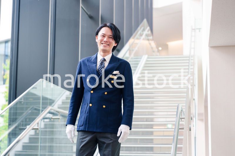 笑顔で接客をするホテルマンの男性