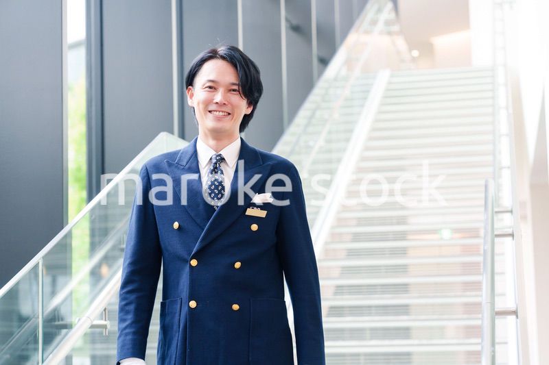 笑顔で接客をするホテルマンの男性