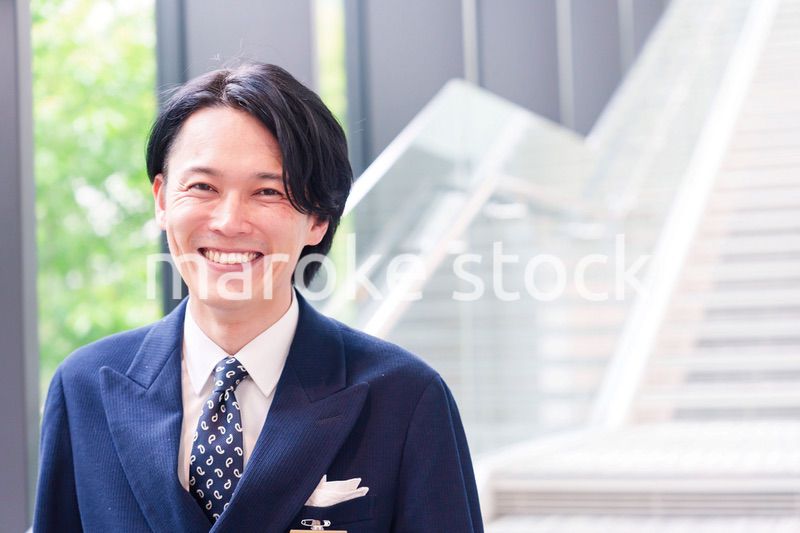 笑顔で接客をするホテルマンの男性