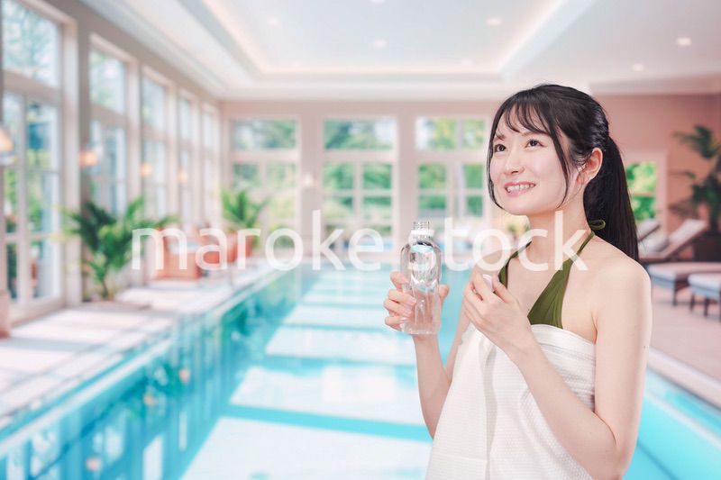 プールで水を飲んでクールダウンする水着姿の女性