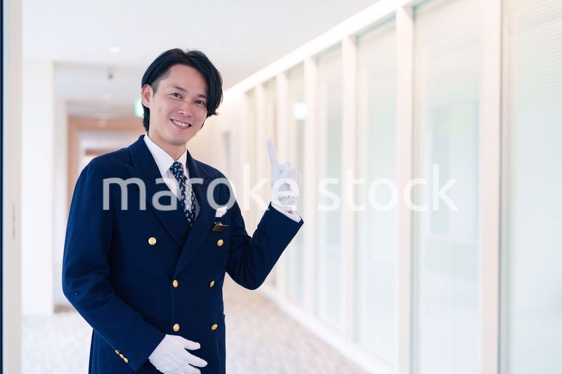 笑顔で接客をするホテルマンの男性