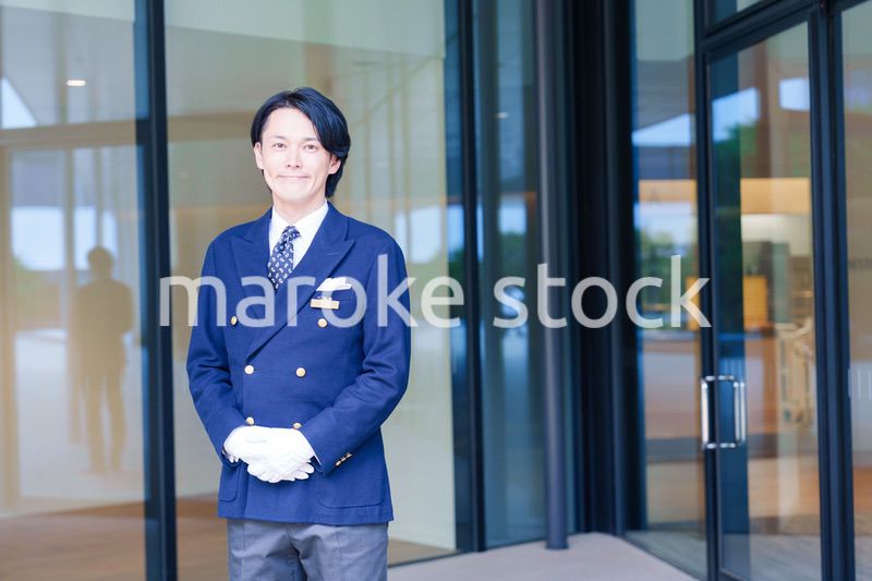 笑顔で接客をするホテルマンの男性
