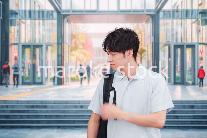 大学のキャンパス内を歩く男子学生