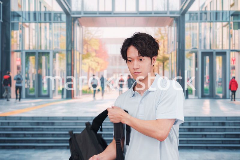 大学のキャンパス内を歩く男子学生