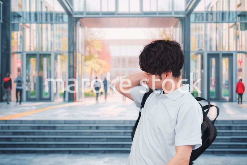 大学のキャンパス内を歩く男子学生