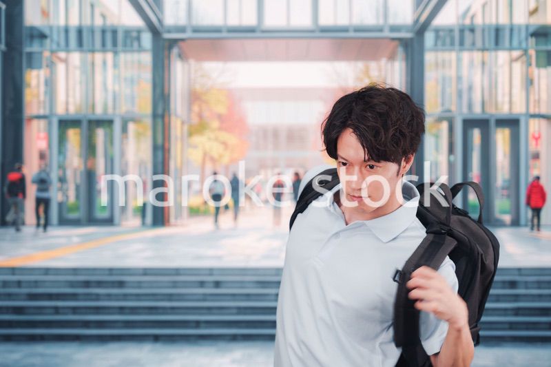 大学のキャンパス内を歩く男子学生