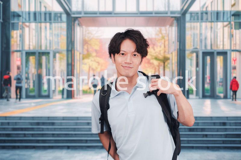 大学のキャンパス内を歩く男子学生