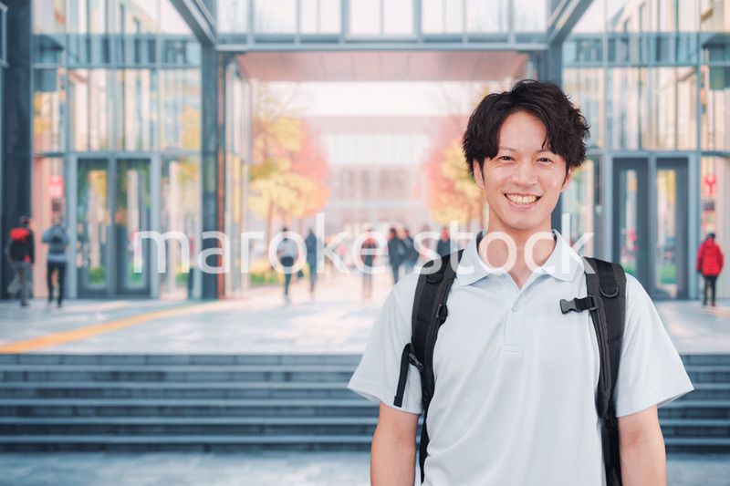 大学のキャンパス内を歩く男子学生