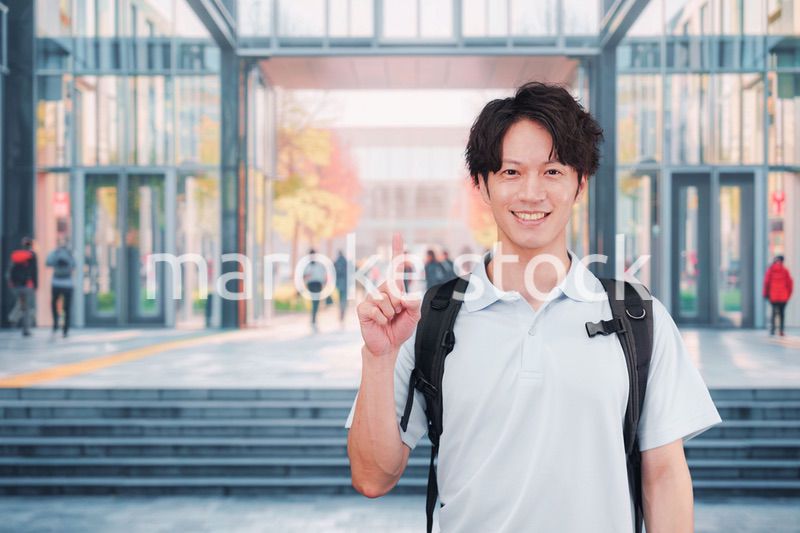 大学のキャンパス内を歩く男子学生