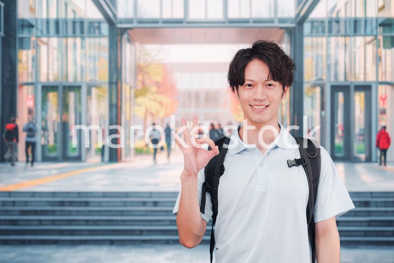 大学のキャンパス内を歩く男子学生