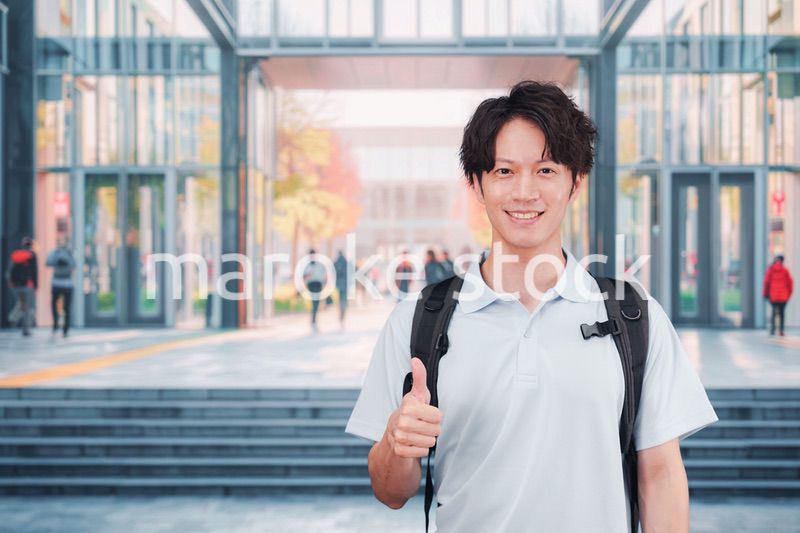 大学のキャンパス内を歩く男子学生