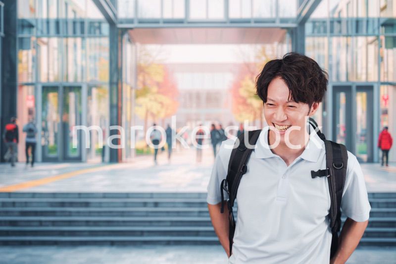 大学のキャンパス内を歩く男子学生