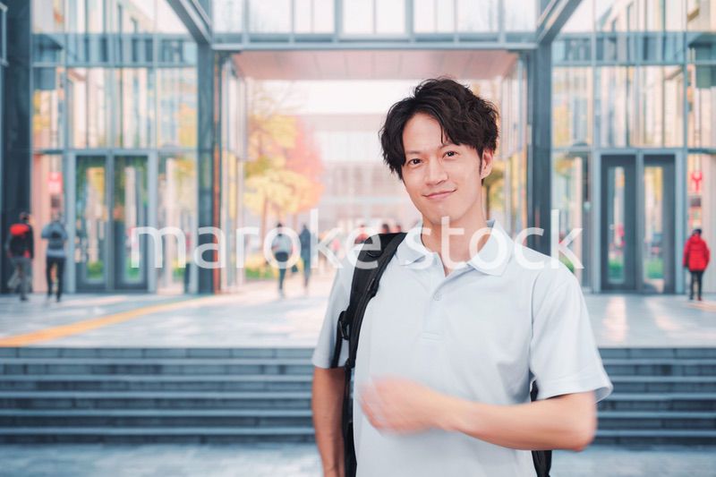 大学のキャンパス内を歩く男子学生