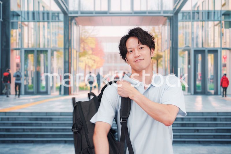 大学のキャンパス内を歩く男子学生