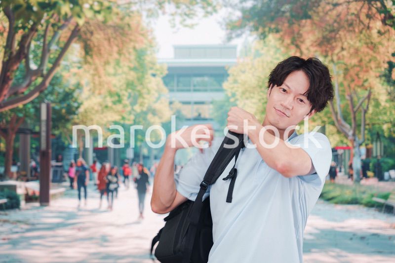 笑顔でキャンパスを歩く大学生の男性