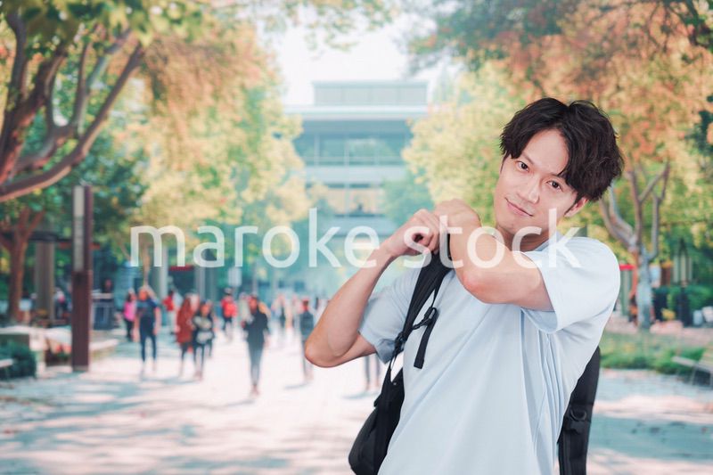 笑顔でキャンパスを歩く大学生の男性