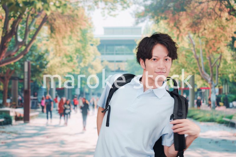 笑顔でキャンパスを歩く大学生の男性