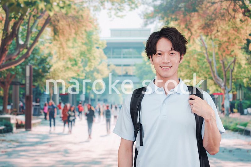 笑顔でキャンパスを歩く大学生の男性