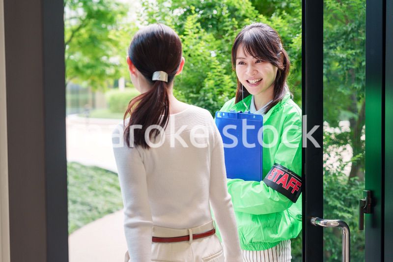 お客様を笑顔で案内するイベントスタッフ