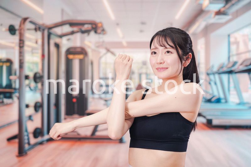 ジムでストレッチをする若い女性
