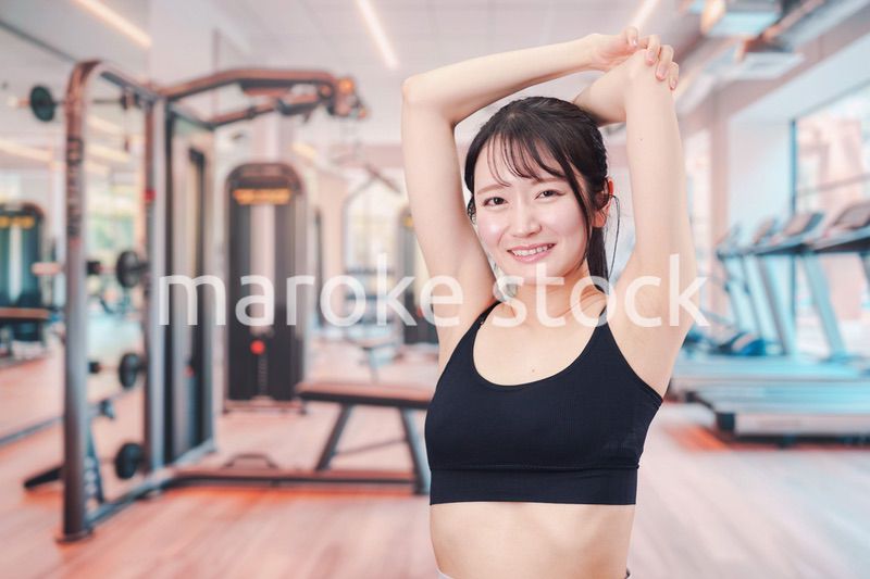 ジムでストレッチをする若い女性