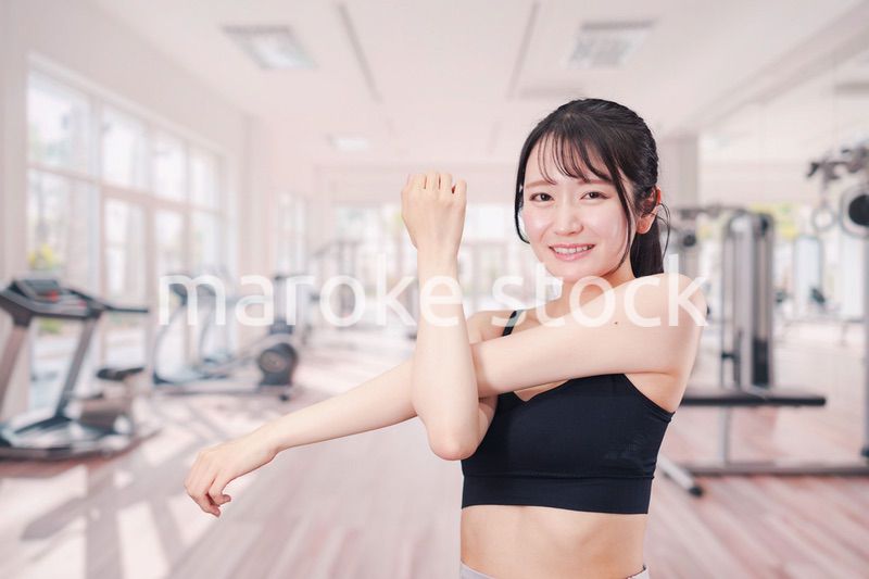 ジムでストレッチをする若い女性