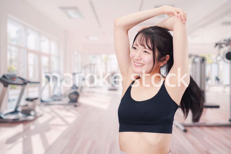 ジムでストレッチをする若い女性