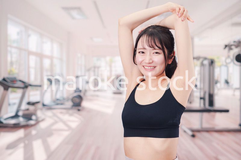 ジムでストレッチをする若い女性