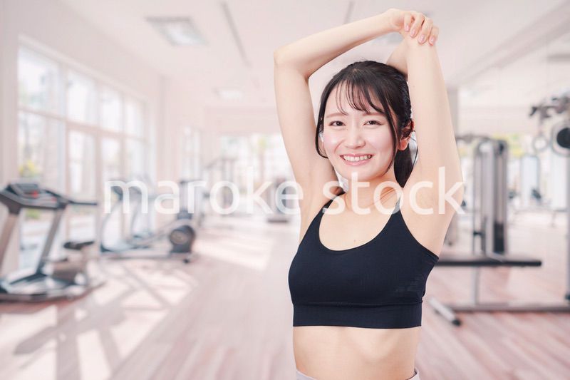 ジムでストレッチをする若い女性