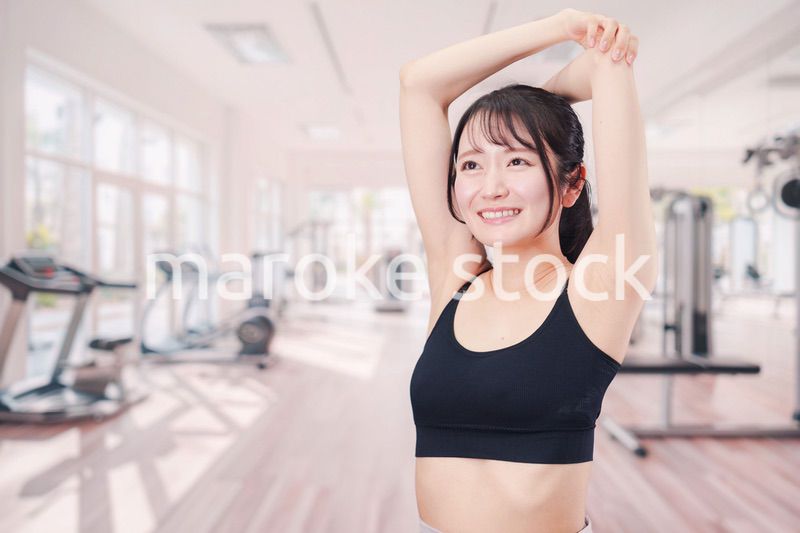 ジムでストレッチをする若い女性