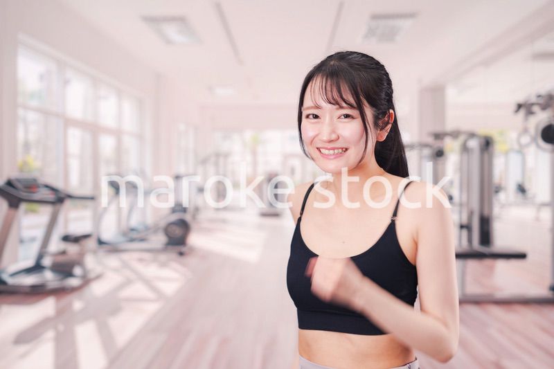 ジムでランニングをする若い女性