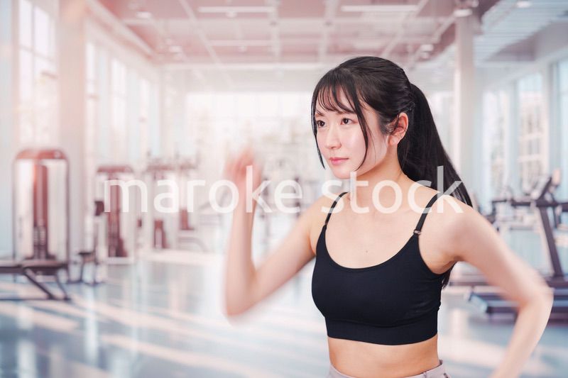 ジムでランニングをする若い女性