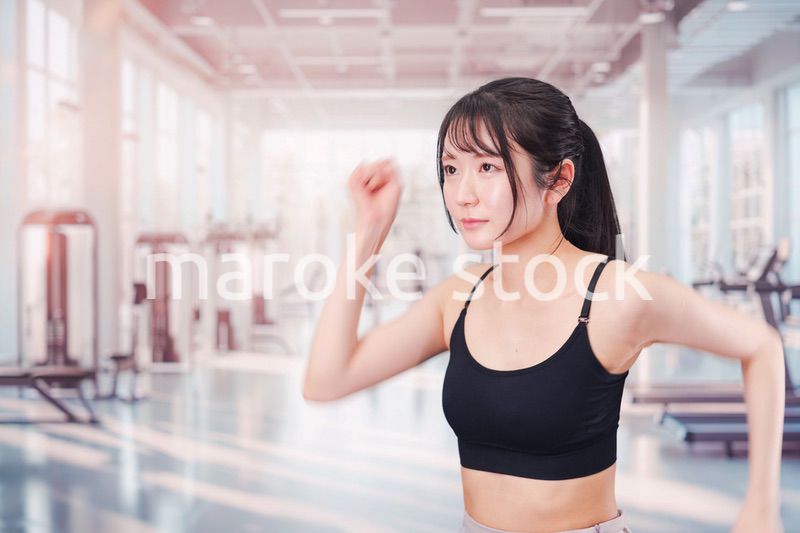 ジムでランニングをする若い女性