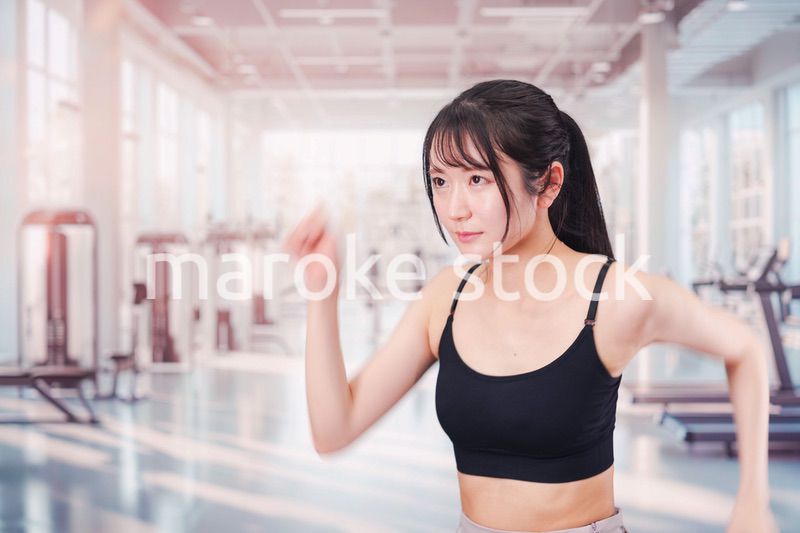 ジムでランニングをする若い女性