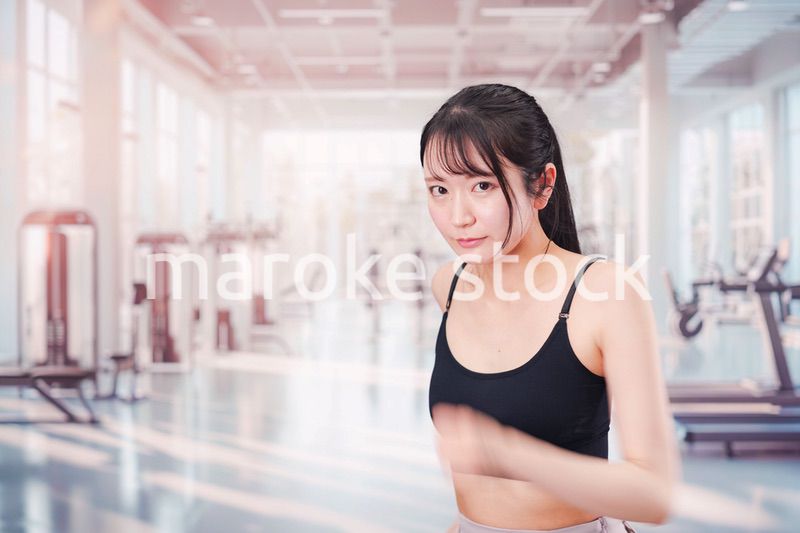 ジムでランニングをする若い女性