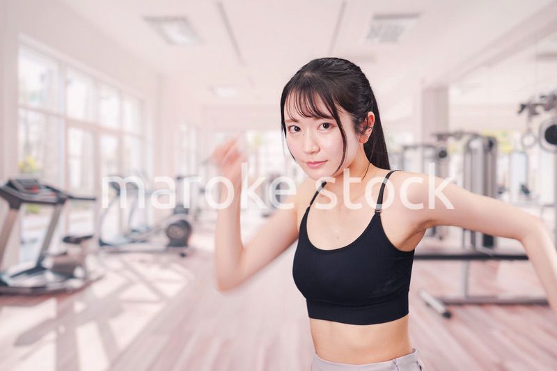 ジムでランニングをする若い女性