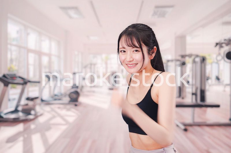 ジムでランニングをする若い女性