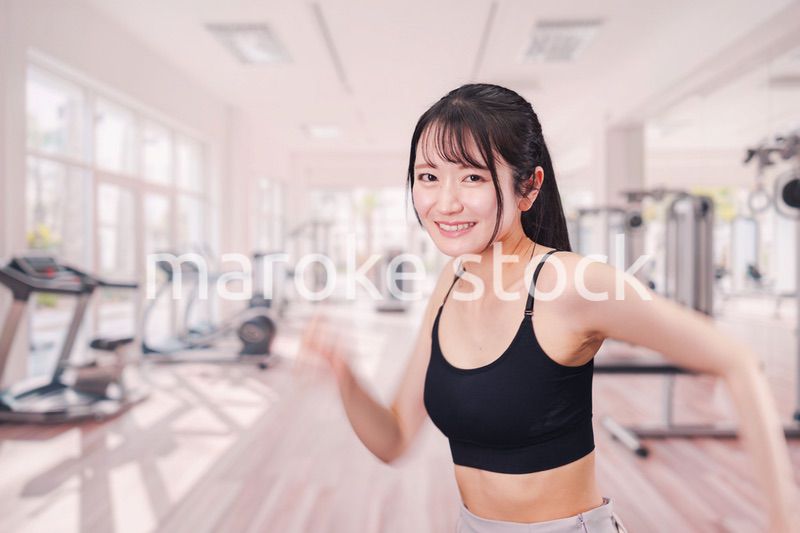 ジムでランニングをする若い女性