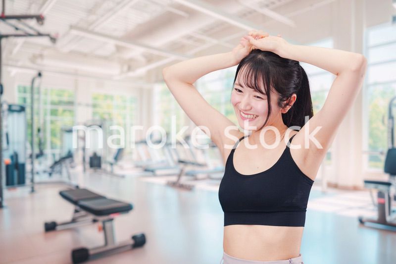 ジムでストレッチをする若い女性