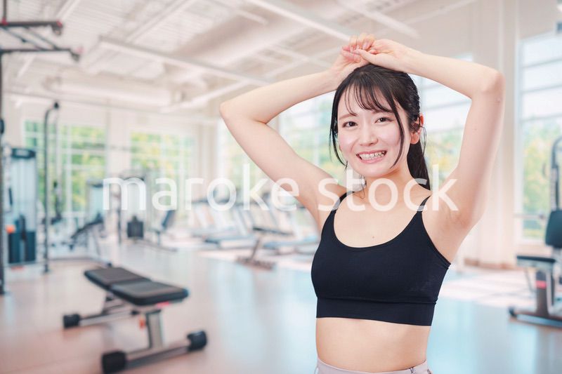 ジムでストレッチをする若い女性