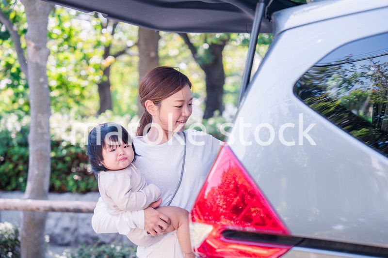 赤ちゃんと一緒に車に乗るお母さん