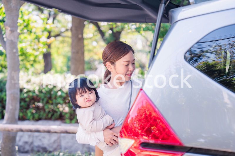 赤ちゃんと一緒に車に乗るお母さん